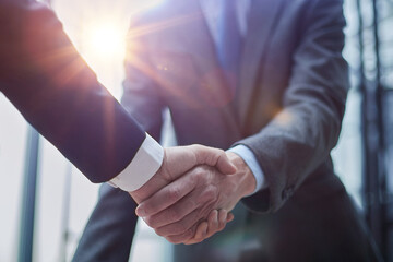 two diverse professional business men executive leaders shaking hands at office meeting