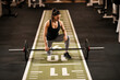 © Dusan Petkovic - A fit sportswoman is preparing to lift barbells in a gym.