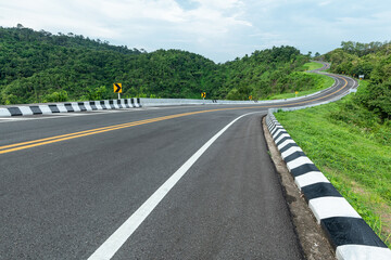 Wall Mural - long curvy forest asphalt road over the hills. beautiful curved road in the forest. side view of roa