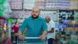 © Marco - Male shopper pushing shopping cart at grocery store aisle browsing for products on shelves depicting consumer lifestyle habbits at supermarket