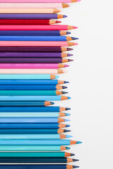 Wall Mural - Multi-colored pencils lie on a white table, the violet range of colors