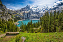 Amazing Tourquise Oeschinnensee With Waterfalls, Wooden Chalet And Swiss Alps, Berner Oberland, Switzerland.