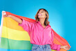 © BamBam/peopleimages.com - Lgbtq, lesbian and woman with support, pride flag or equality on blue studio background. Female person, rainbow or model with symbol for queer community, transgender rights or freedom with self love