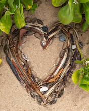 Close-up Of Dried Seed Pods, Twigs And Stones Shaped Into A Heart Displayed On The Sand On Maluaka Beach; Maui, Hawaii, United States Of America