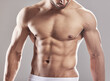 © Alexis Scholtz/peopleimages.com - Sexy man, underwear model and muscle with strong chest, abs and body with wellness in studio. Bodybuilder, exercise and healthy male person with gray background and muscles from fitness and workout