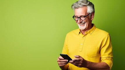 Middle-aged man is using a cell phone on a green background.