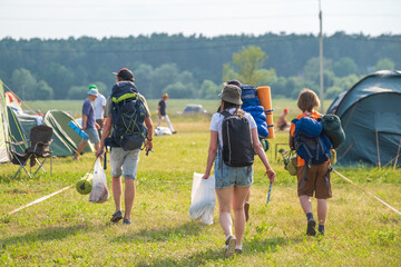 Group of people with backpacks walking on campsite