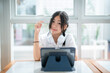 © Thinapob - Happy of cute smiles Asian of attractive young Cute girl little wearing headphones and listening music using digital tablet working from at the cafe.Online education, e learning concept.