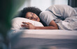 © Lategan/peopleimages.com - Sleeping, black woman and bed with morning nap in home with rest feeling calm with peace. House, bedroom and tired female person relax and comfortable on a pillow with blanket dreaming on weekend