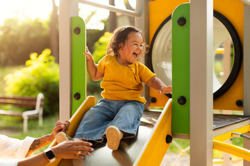 Adorable Chinese Baby Girl Riding Slides At Playground In Park