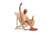 © Ljupco Smokovski - Young man in swimwear sitting on a beach chair and listening to music from a smartphone