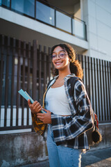 Wall Mural - Portrait of mixed race student girl looking at camera. She is holding some folders.