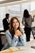 © Maria Vitkovska - Portrait of smiling confident American businesswoman, CEO, manager looking at camera sitting in modern office with colleagues on background.  Attractive happy secretary sitting at workplace. Career