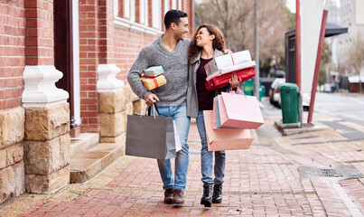 Happy couple, shopping bags and walking in city with gifts for fashion, clothing or buying outdoors. Man and woman in relationship with smile for customer discount, purchase or payment in urban town