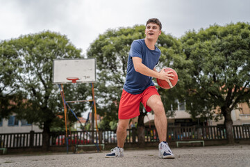 One caucasian teenager stand on basketball court with ball