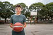 © Miljan Živković - One caucasian teenager stand on basketball court with ball