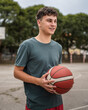 © Miljan Živković - One caucasian teenager stand on basketball court with ball