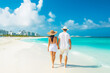 Cancun travel destination. Two tourists walking on beach front view. Tour tourism exploring.