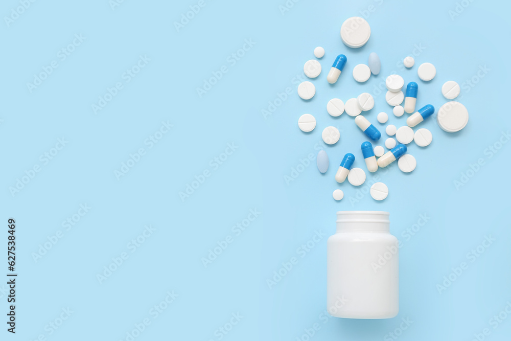 Bottle with pills on blue background
