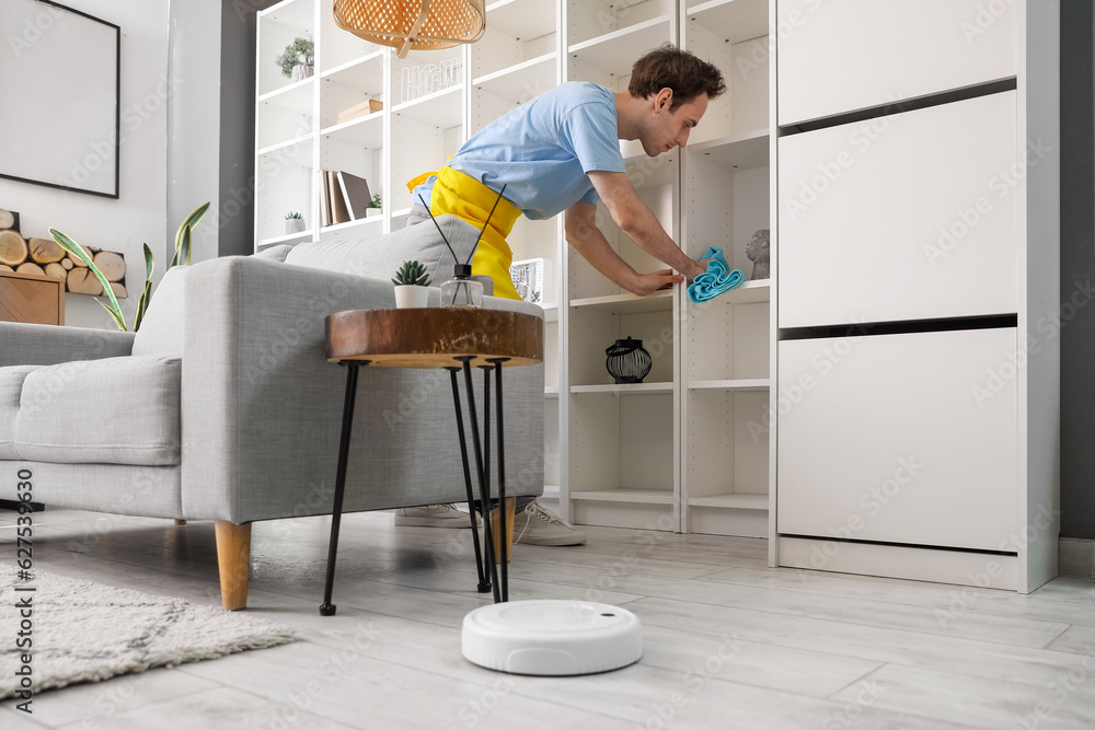 Young man cleaning his apartment