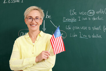 Canvas Print - Female English teacher with USA flag in classroom