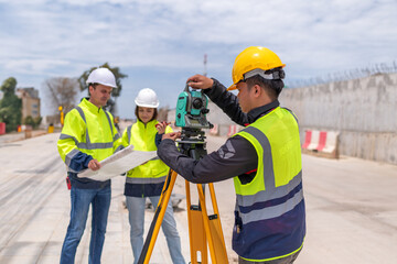 Portrait surveyors wearing uniform conversation notebook and blueprint check inspection by theodolite camera to measurement level position road construction site is industry transportation concept.