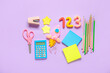 Rocket and numbers made of plasticine with stationery on lilac background