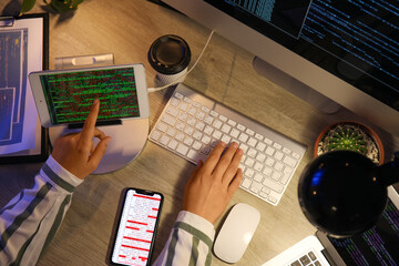 Female programmer working with computer in office at night, top view