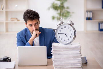 Wall Mural - Young male employee in time management concept