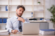 © Elnur - Young male employee working in the office