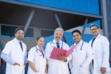 Wall Mural - Senior doctor looking medical report and discussing to junior doctor team