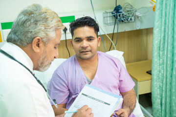 Wall Mural - Doctor discussing with patient and note down prescription while medical examination.