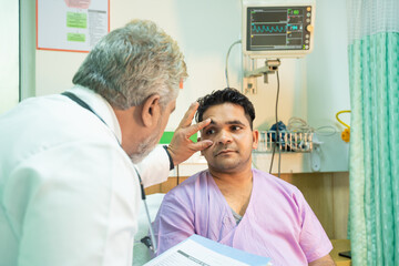 Wall Mural - Doctor checking patient eye in medical examination at hospital.