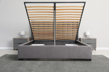 Sticker - Comfortable bed with storage space for bedding under lifted slatted base in room