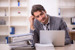 © Elnur - Young male employee unhappy with excessive work in the office