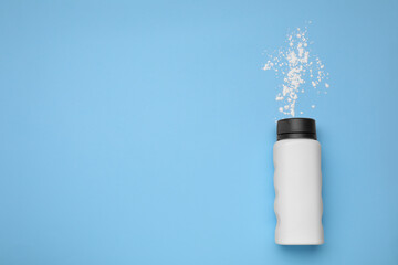 Wall Mural - Bottle and scattered dusting powder on light blue background, top view with space for text. Baby cosmetic product