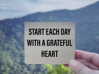 Wall Mural - Motivational and inspirational wording. Start Each Day With A Grateful Heart. With blurred styled background.
