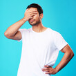 Man, face palm and mistake in studio with thinking, regret and anxiety for fail by blue background. Young guy, student and cover eyes with stress, memory and shame for bad decision with depression
