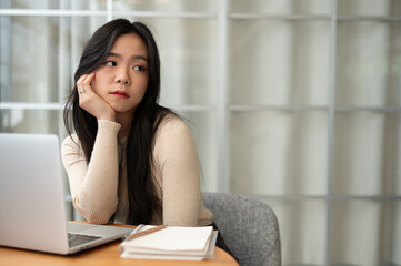 Wall Mural - A bored Asian female college student, looking away from the camera with a boring face