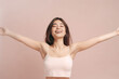 a charming smile and relaxed demeanor, a pretty lady in an underwear dress raises her arms wide, revealing smooth armpits against pastel pink old rose background. generative AI.