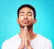 © JoshuAA/peopleimages.com - Praying, man and hands in meditation or worship to God for faith or belief in spirituality, mindfulness and peace in studio. Christian, prayer and person with religion and zen on blue background