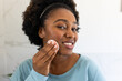 © Wavebreak Media - Happy plus size african american woman applying powder on face in bathroom
