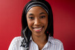 © Wavebreak Media - Portrait of a african american businesswoman smiling against red background