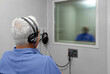 © ATRPhoto - Audiologist woman doing the hearing exam to a mixed race man patient using an audiometer in a special audio room. Audiometric testing. Hearing loss treatment.