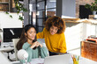 © Wavebreak Media - Happy biracial female colleagues with laptop and tablet discussing work in office