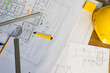 © Wavebreak Media - Close up of architecture project of building and yellow helmet over design equipment