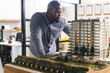 © Wavebreak Media - Focused casual african american businessman inspecting model of building on table in office