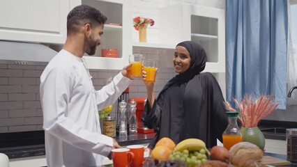 Wall Mural - Happy couple wearing traditional outfits from the emirates spending  time in the kitchen of their beautiful modern apartment in Dubai