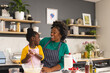 © Wavebreak Media - Happy african american mother and daughter baking pancakes in kitchen at home