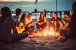 Blurred group of Friends sit around a bonfire on the beach near bonfire on a beach at night playing guitar singing songs. 

